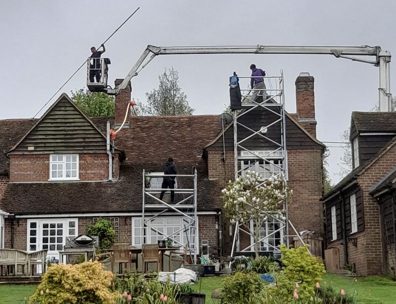 The Roof Moss Cleaners using cherry picker and scaffolding to clean roof safely and professionally in Irthlingborough, Northamptonshire